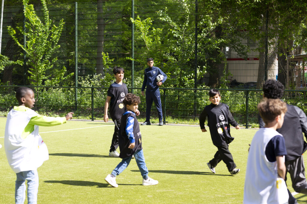 Kinderen voetballen op het nieuwe voetbalveld.