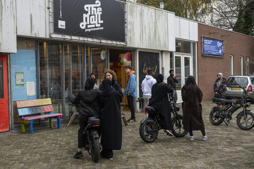 Jongeren met fatbikes staan bij jongerencentrum de Mall met onderzoeker Marjan Hagenzieker te praten